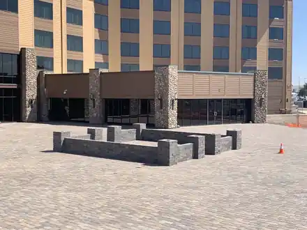 Block seat walls framing a paver court outside a hotel entrance