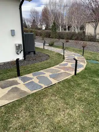 Farber Project: a flagstone path set in river rock along the side of a house