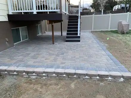 Mills Project: a paver patio with a soldier course border under a deck stair