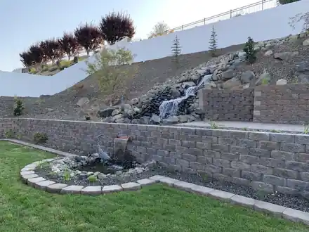 Scott Project finished: a rock waterfall down the slope into a pond framed by two block walls