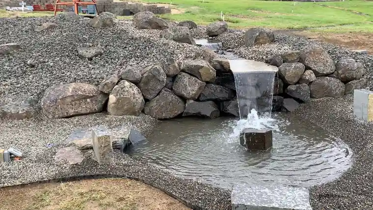 Staufer Project: a stone spillway pouring into the finished pond