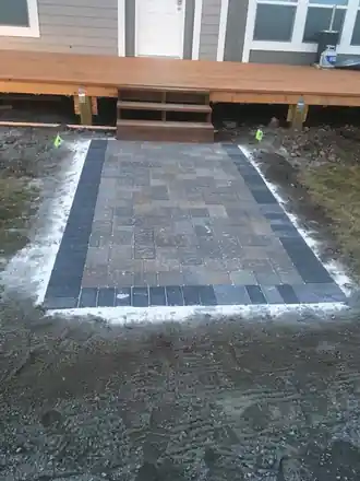 Wheeler Project: a small paver pad at the foot of a deck stair